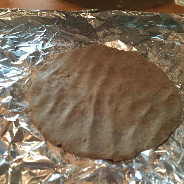 Millet flour dough pressed by hand to form a disc